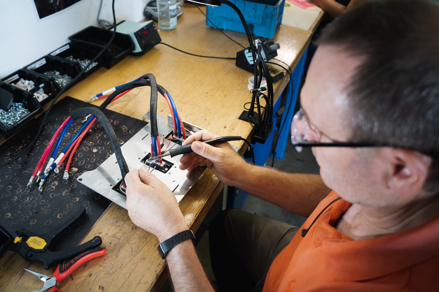 Vrijwilliger repareert elektronica aan een werkbank in het Repair Caf&eacute;